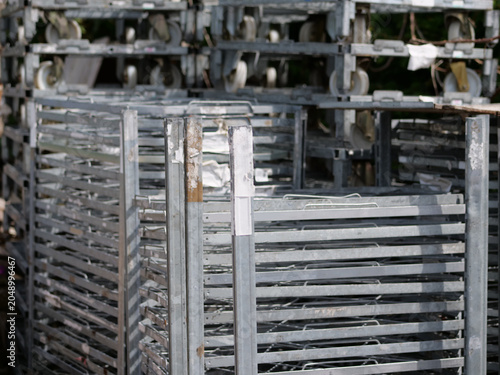 Obraz na płótnie A medium shot 
depicting several empty steel trolley 
racks stacked closely together at a 
commercial farm facility