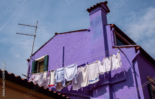 VENICE, ITALY – Vibrantly painted houses in bold colors line the streets of Burano Island in the Venetian lagoon, where the centuries-old tradition of colorful facades add unique flair. 