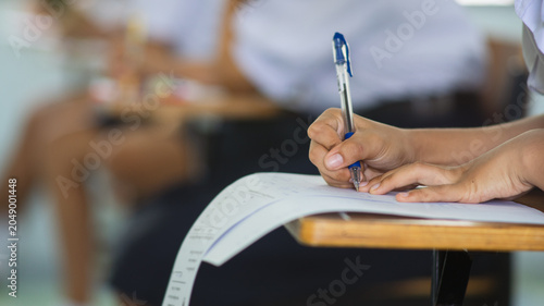 Billede på lærred Close-up of a student's hand diligently writing on an exam paper during a school test