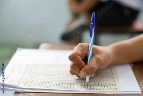 Foto Close-up of a student's hand diligently writing on an exam paper during a school test