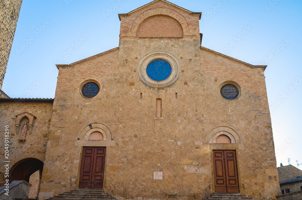 Naklejka premium View of cathedral facade of San Gimignano, medieval village of Tuscany (Province of Siena, Italy); is world famous for its renaissance monuments and white wine production (named 