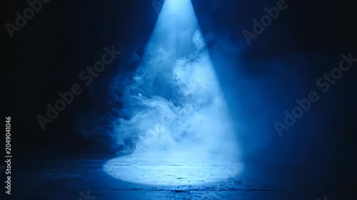 Single blue spotlight shining on misty dark floor.