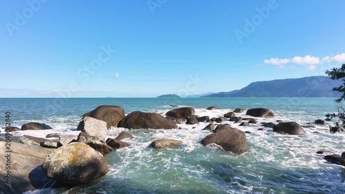 Tropical beach with waves hitting on the rocks at Brazil