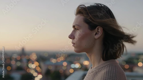 Young Man Looking Out over City Lights at Sunset