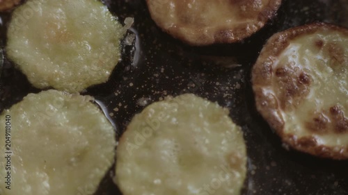 The cook turns the zucchini fried in oil in a pan with a fork