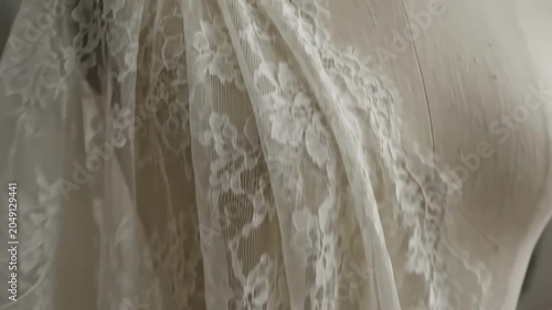 Bridal dress design process in a studio with detailed lace work and fabric arrangements
