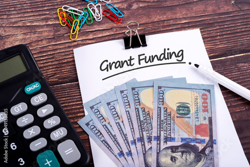 Financial bill and paper with text Grant Funding