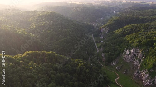 Aerial Golden Hour Over Lush Forest Valley and Winding Road