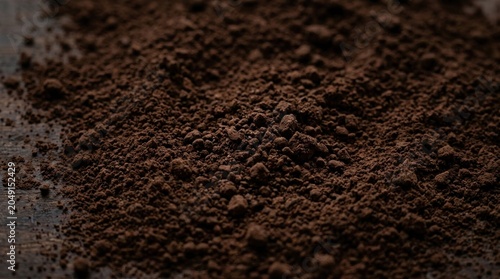 Dark brown ground coffee powder macro background texture.