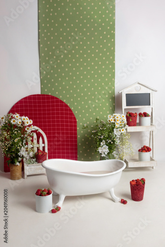 Baby bathtub with strawberries and flowers in a studio setup