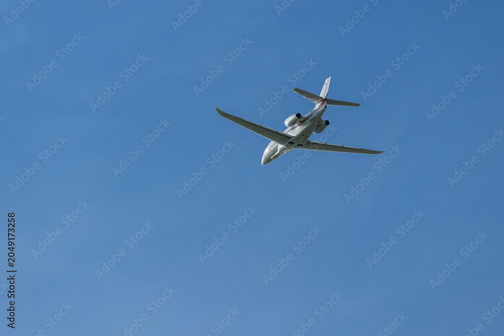 Fototapeta premium Private jet airplane flying high in blue sky over Hostivice