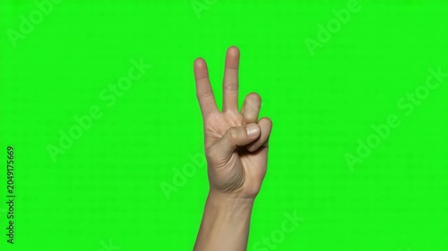 Hand showing the number three sign against a green screen background 4k video