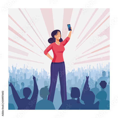 Woman taking a selfie in front of a cheering crowd