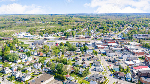 Aerial view of a small town with houses, trees, and commercial buildings