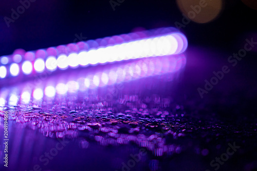 Abstract wet surface with water drops and blurred bokeh light reflections