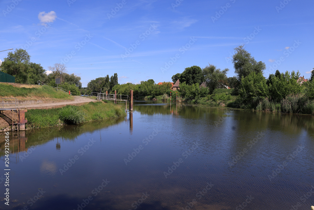 Obraz premium Idyllischer Blick auf den ruhigen Flusslauf der Saale mit grünen Uferlandschaften im Sommer, Merseburg, Saalekreis, Sachsen-Anhalt, Deutschland