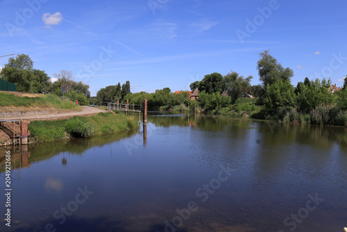 Idyllischer Blick auf den ruhigen Flusslauf der Saale mit grünen Uferlandschaften im Sommer, Merseburg, Saalekreis, Sachsen-Anhalt, Deutschland