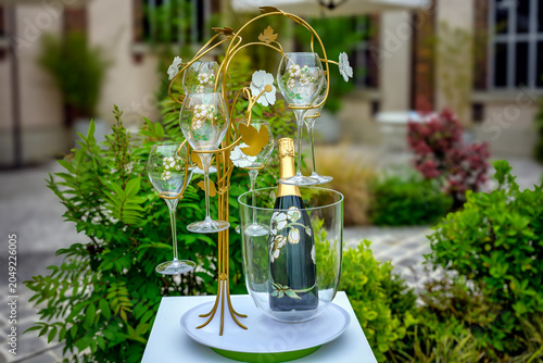 2025-04-24 A BEAUTIFUL CHAMPAGNE GLASSES WITH COLORFUL DESIGN AND A BEAUTIFUL CHAMPAGNE BOTTLE HELD UP IN A METAL FLORAL DISPLAY IN EPERNAY FRANCE