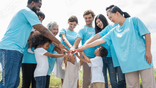 Foto Diverse volunteers unite outdoors in joyful collaboration wearing matching t-shirts beneath bright open sky during community service initiative promoting teamwork and connection