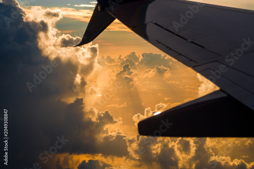 Slika na platnu Massive fluffy cumulus cloud formations fill the aerial space outside flying passenger airplane window during high altitude travel