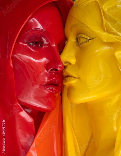 A close-up of two colorful, glossy sculptures of women's faces