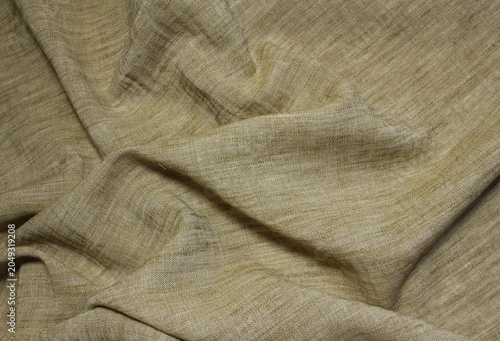 Texture of light brown polyester cloth. Close up of beige linen like fabric background.