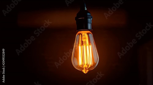 Illuminated antique bulb emits warm, inviting glow against dark background