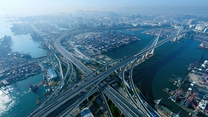 Aerial view of bridge and highway over river with city skyline