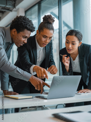 Diverse Business Team Meeting Around Laptop in Office
