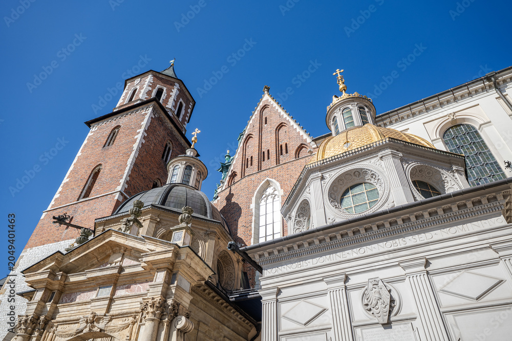 Obraz premium View of church towers and domes against clear blue sky in a historic city. Krakow cathedral stands tall against clear blue sky during bright daylight in Poland