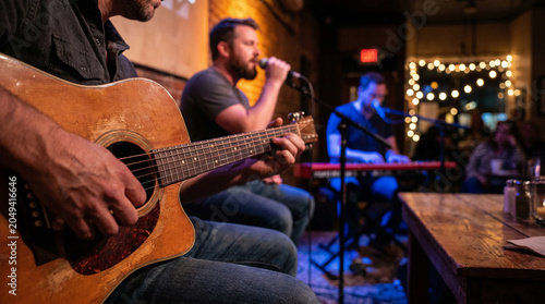 Live acoustic band performing in a dimly lit bar