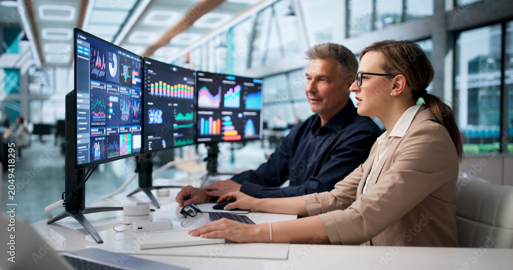 © Andrey Popov - Financial Analyst And Colleague Monitor Business Data Dashboard © Andrey Popov - Financial Analyst And Colleague Monitor Business Data Dashboard
