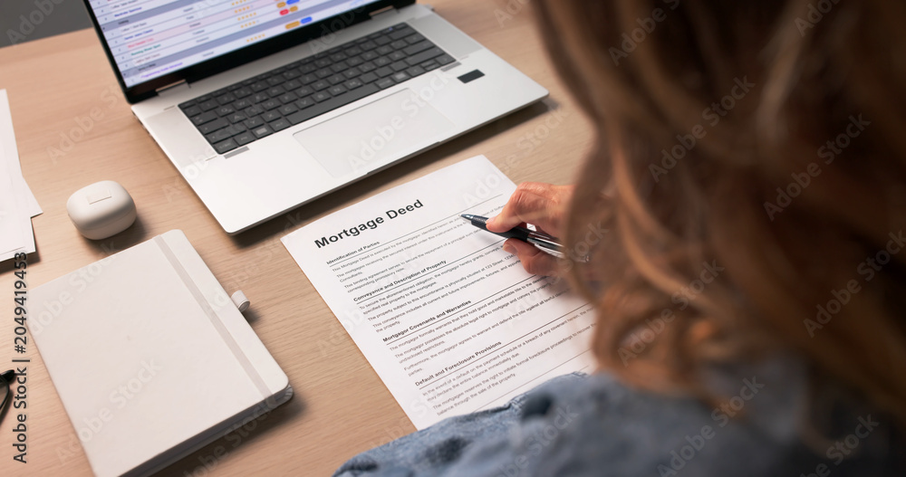 Obraz premium Woman Reviewing Important Mortgage Deed Document
