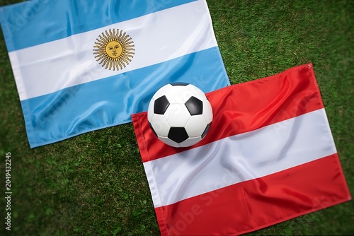 Argentine and austrian flags with soccer ball on grass