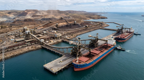 Large cargo ship loading at industrial bulk carrier port.