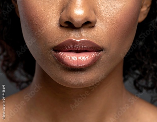 A woman's face with curly hair and glossy lips