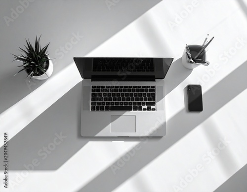 Top view minimalist workspace with closed laptop centered on clean desk, dramatic window shadow pattern, modern business aesthetic, high resolution
