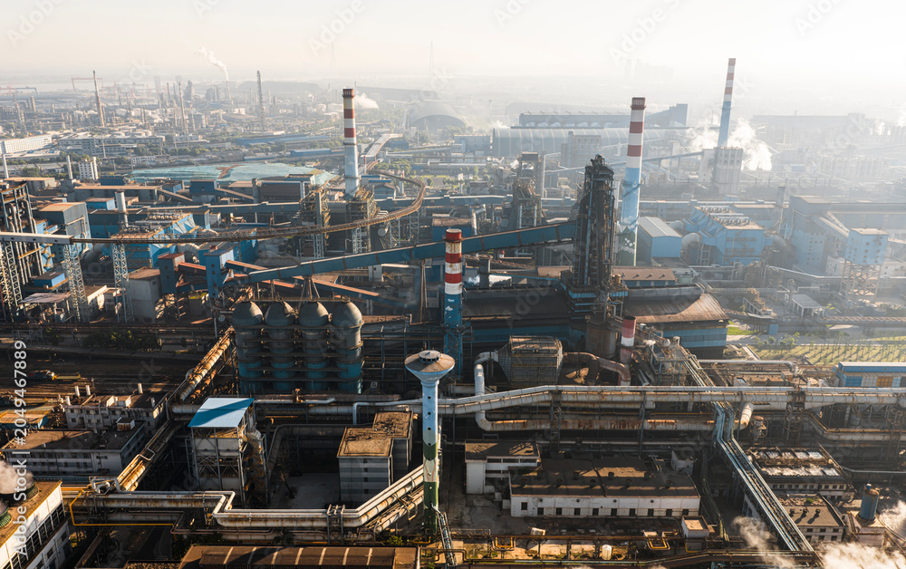 Obraz premium Aerial view of Wuhan steel plant, featuring a complex geometry of massive blast furnaces and intricate pipelines. It reflects China's industry and economy evolution, producing silicon steel for electr