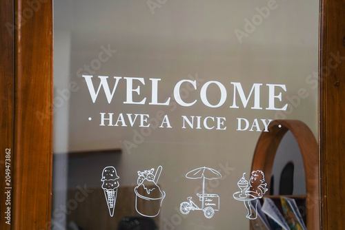 Konstfotografi Closeup welcome word on cafe or restaurant hang on door.