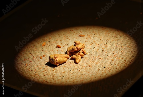 Spotlight on scattered peanuts on textured surface.