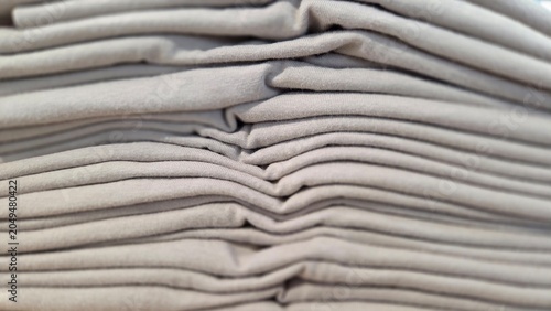 Neatly folded brown fabric pieces stacked together, showcasing soft textile texture and organized cloth arrangement for retail and home concepts