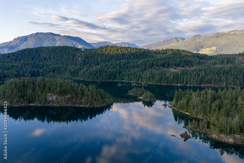 Obraz premium Calm Mountain Lake Reflection Over Dense Evergreen Forests at Harrison Lake, BC, Canada