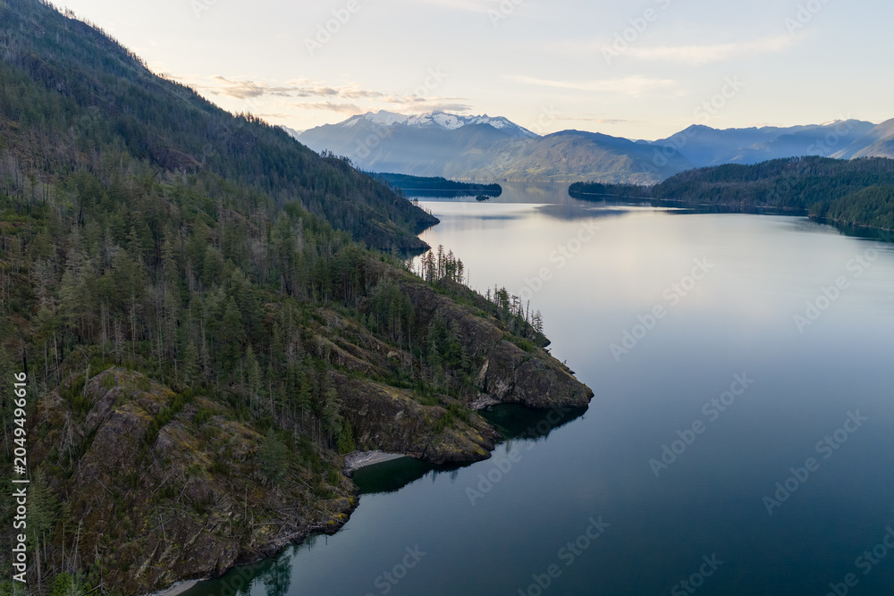 Fototapeta premium Calm Mountain Lake Panorama With Forested Cliffs And Snowy Peaks Over Harrison Lake, BC, Canada