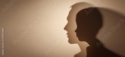 A striking profile silhouette of a man and a child, cast against a warm, textured background, evokes a profound sense of connection, legacy, and shared human experience.