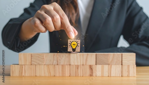 Business professional placing the final wooden block into a structure with a light bulb icon, symbolizing innovation, strategy, and problem solving.