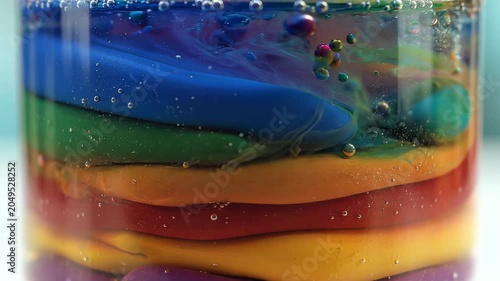 Colorful layers of liquid in a glass.