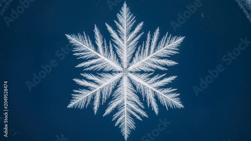 Intricate white snowflake on dark blue background.