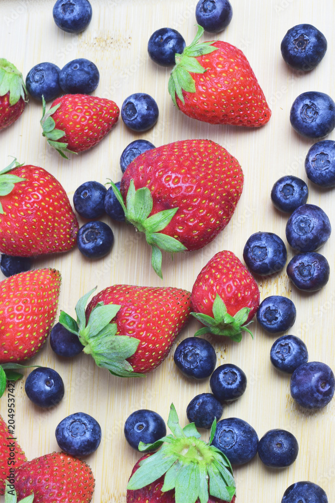 Obraz premium Vertical shot, strawberry and blueberries, zenith view.