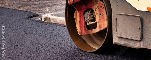 Bilde på lerret Heavy Machinery Lays Asphalt for Road Repairs on a City Street Under Bright Dayl