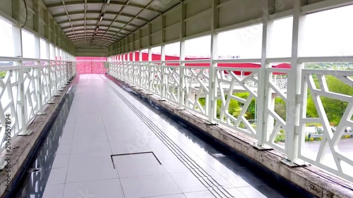 Modern Covered Pedestrian Bridge with Geometric Railings and Urban View